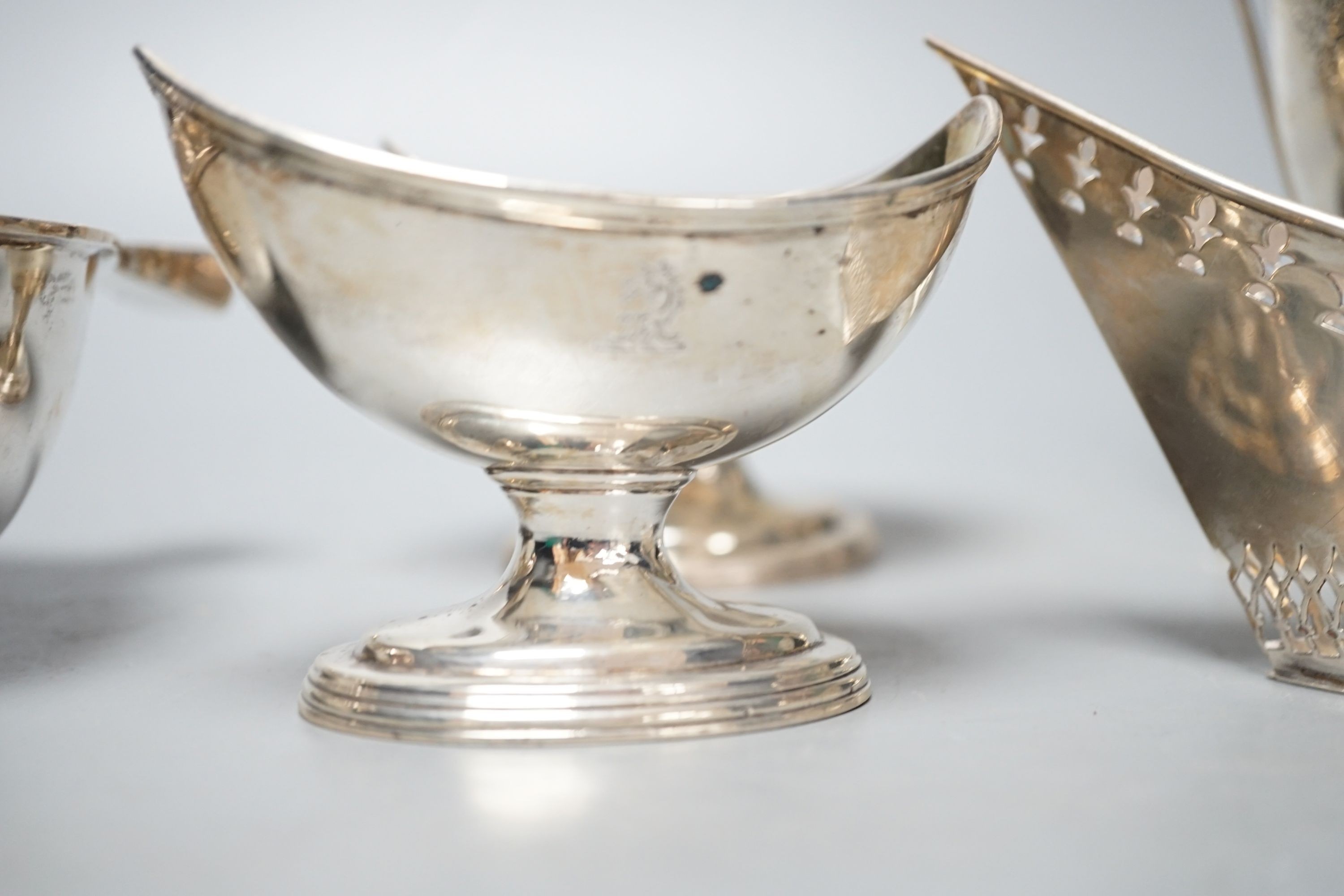A mixed collection of silver to include a Scottish quaich, a pair of George III boat shaped salts, a George III silver helmet shaped cream jug and a pierced boat-shaped bowl, 17oz.